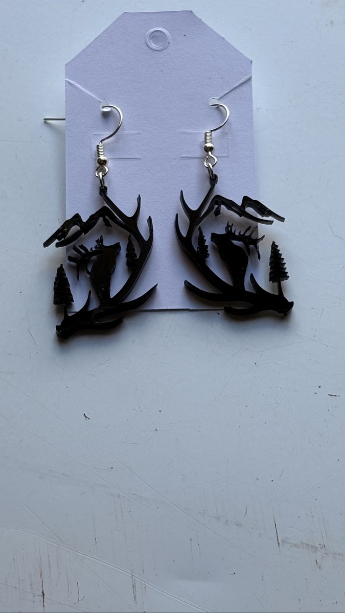 Black laser-cut earrings with an elk, antler, pine, and mountain scene, by KB Custom Creations