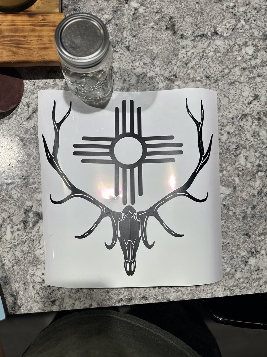 Vinyl decal of an elk skull with antlers and a Zia symbol, made by KB Custom Creations