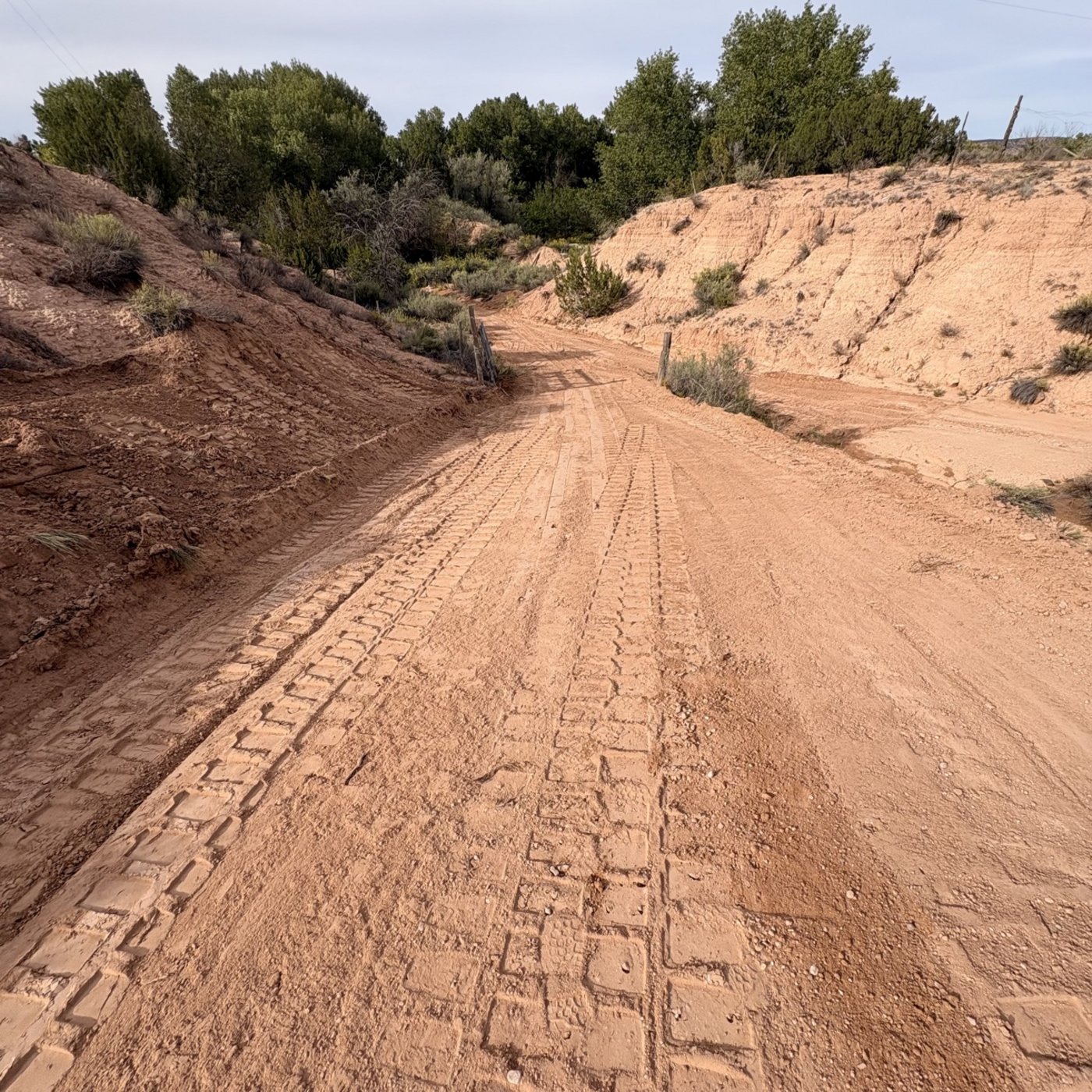 Same dirt road after BK Hauling & Clearing repair — graded smooth with fresh track marks