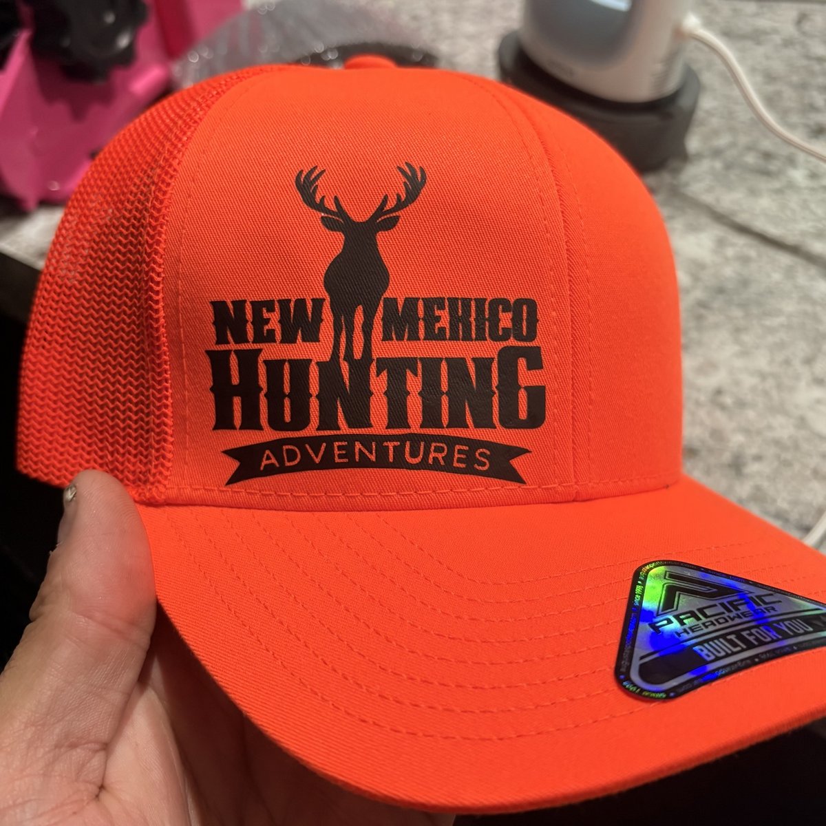 Blaze orange trucker hat with the New Mexico Hunting Adventures logo by KB Custom Creations